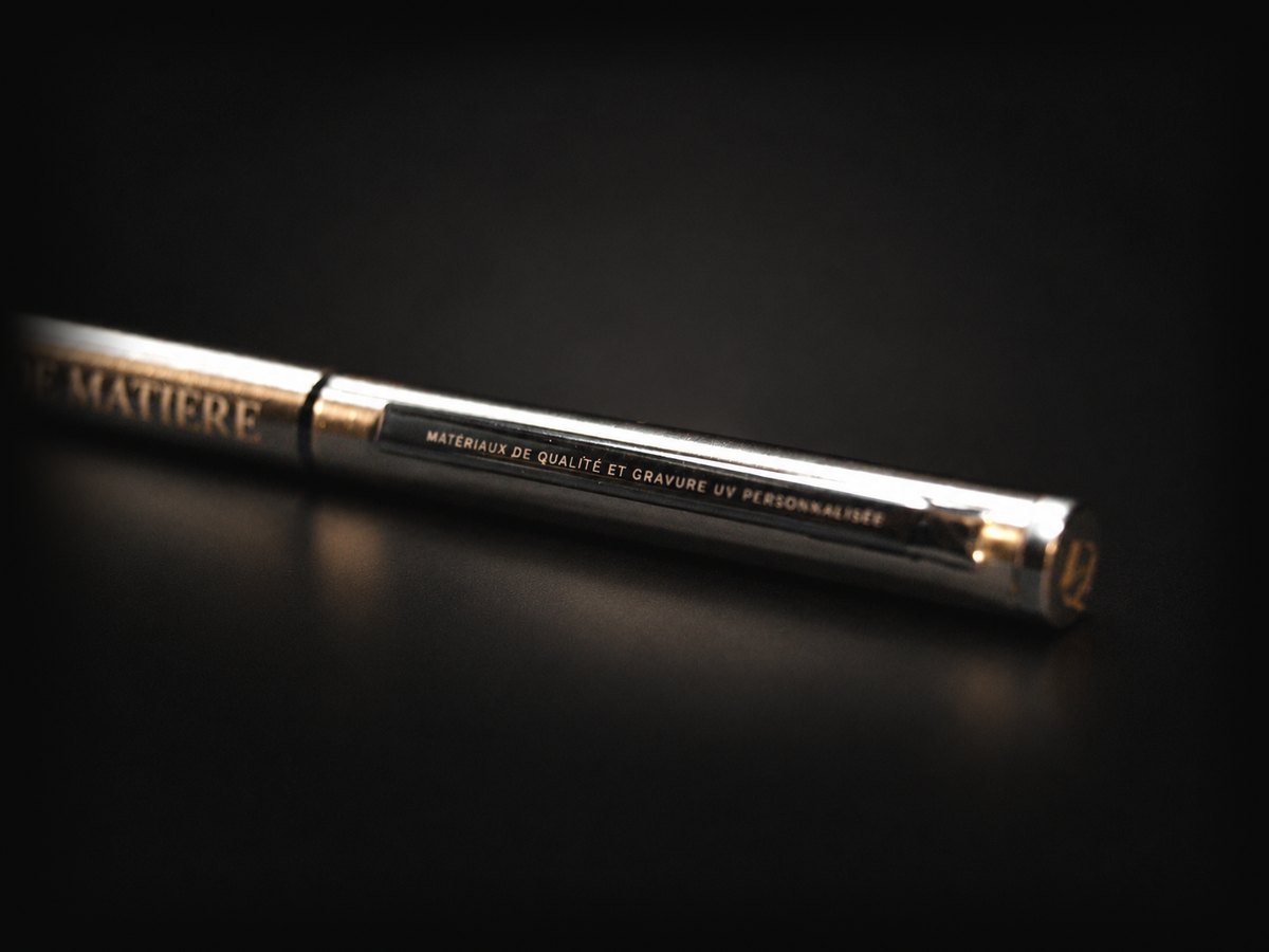 Gros plan sur un stylo métallique gravé d'une inscription fine et nette